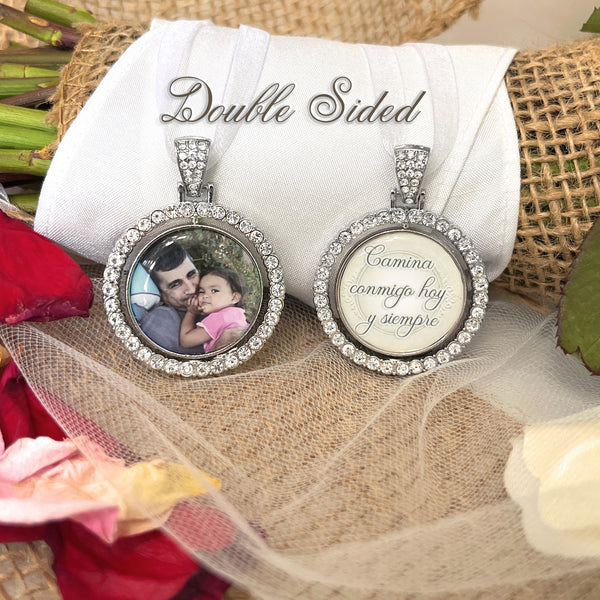 Spanish Memorial bridal bouquet charm comes with photo and custom saying. Image size is roughly 1 inch. Pendant has a rotating center and is double sided. The outer edge is surrounded in rhinestones. The saying is: Camina conmigo hoy y siempre.