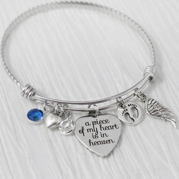 memorial bangle bracelet with a piece of my heart is in heaven charm, 2 custom birthstones, small heart, baby footprint charm and angel wing charm.