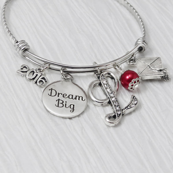 Personalized dream big bangle bracelet with custom rhinestone letter and graduation cap charm. custom year charm with red bead for graduate graduation